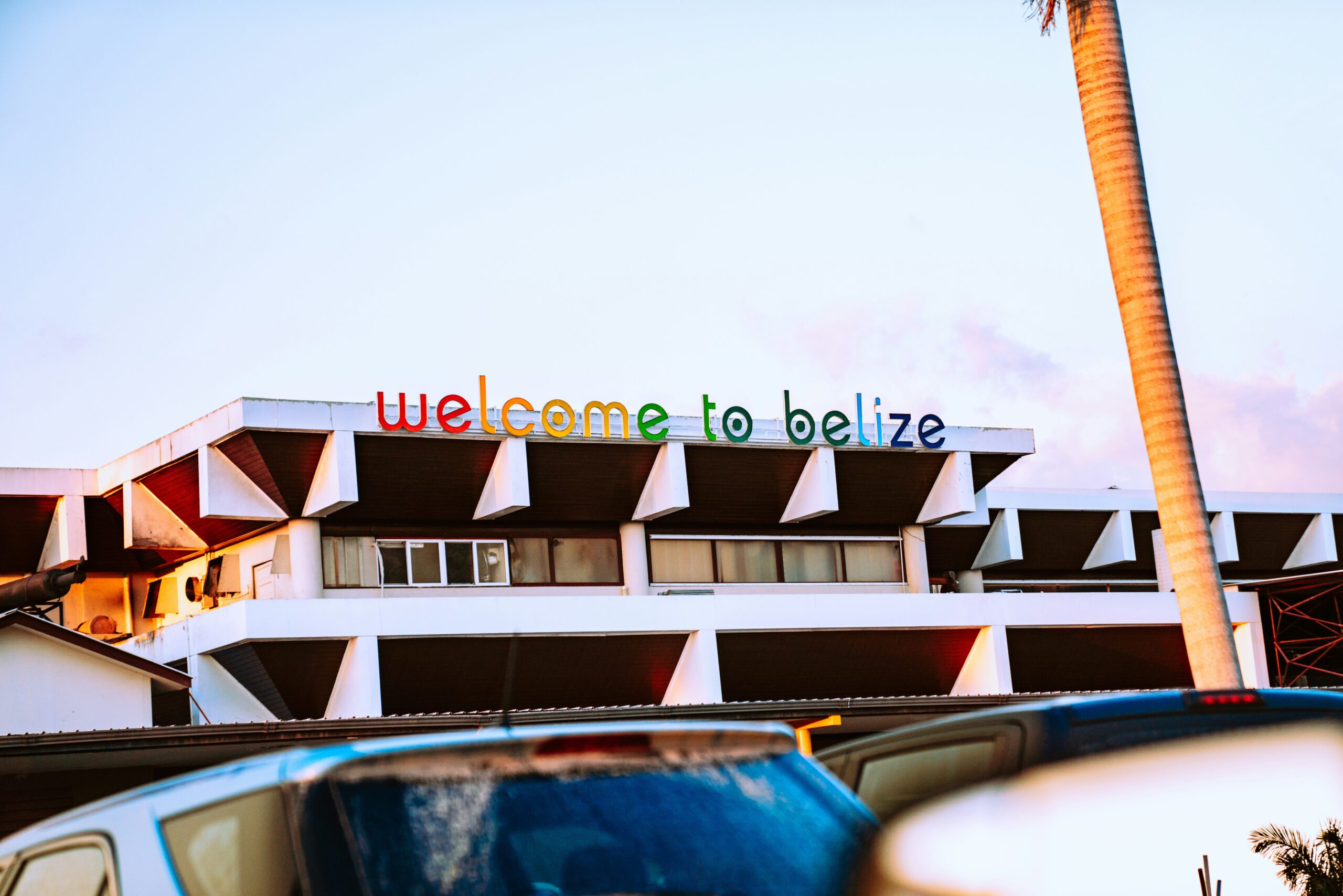 A building at the Belize International Airport that says Welcome To Belize in rainbow colors.