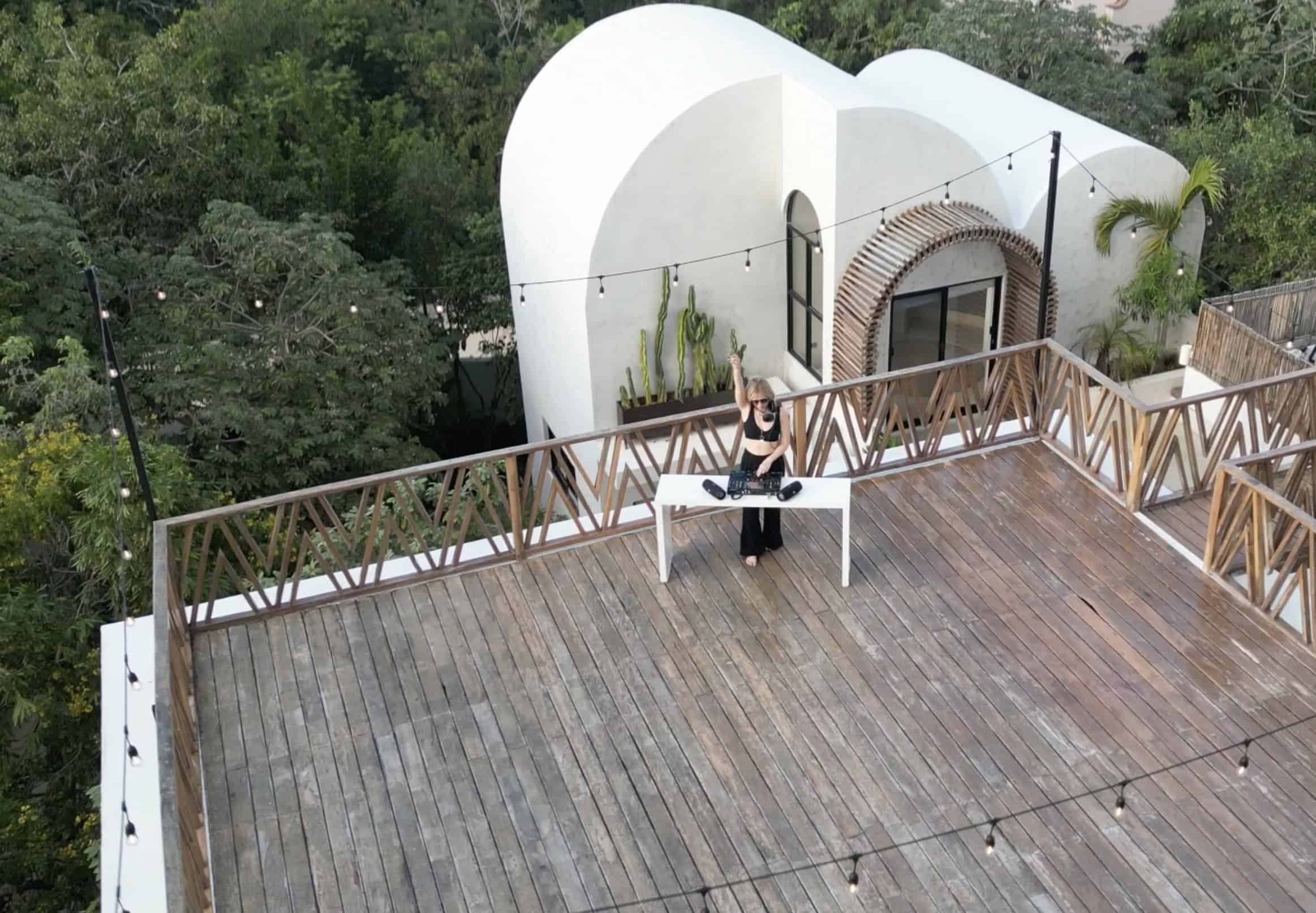 blonde-woman-in-black-djing-on-Tulum-villa-deck