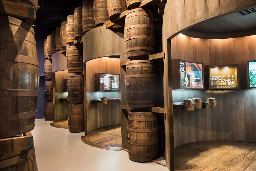 A wall of wooden barrels with informative and rum displays.