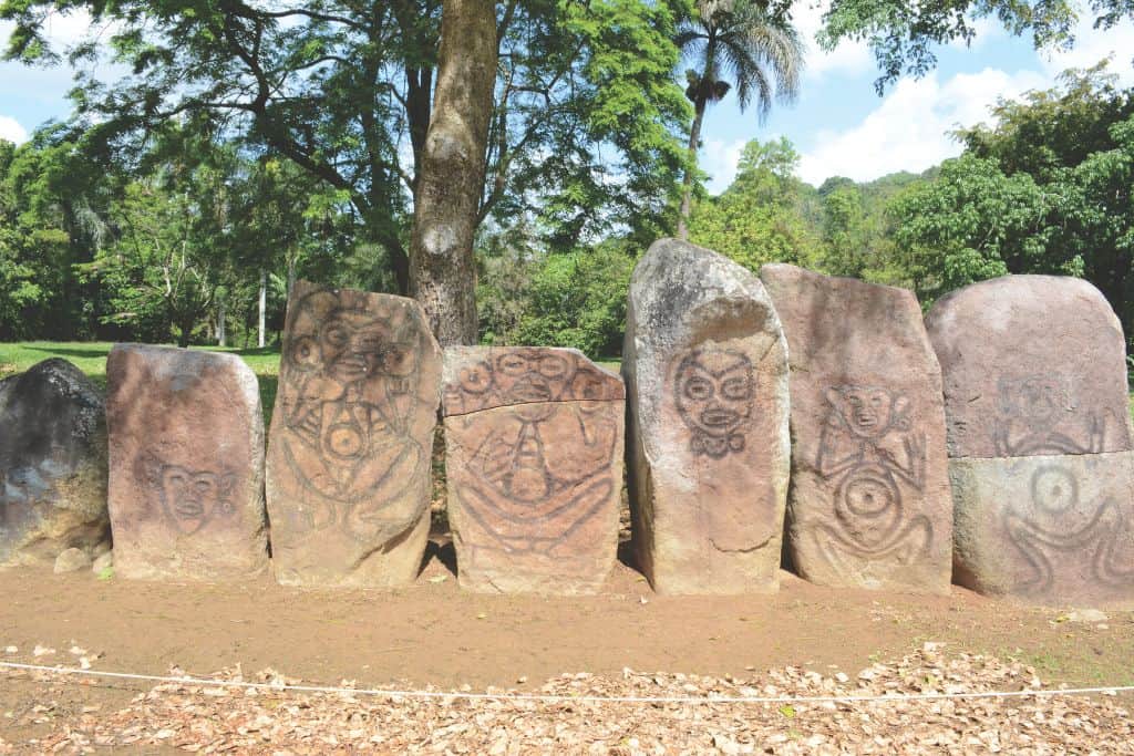 A line of tan stones decorated with ancient drawings of people.