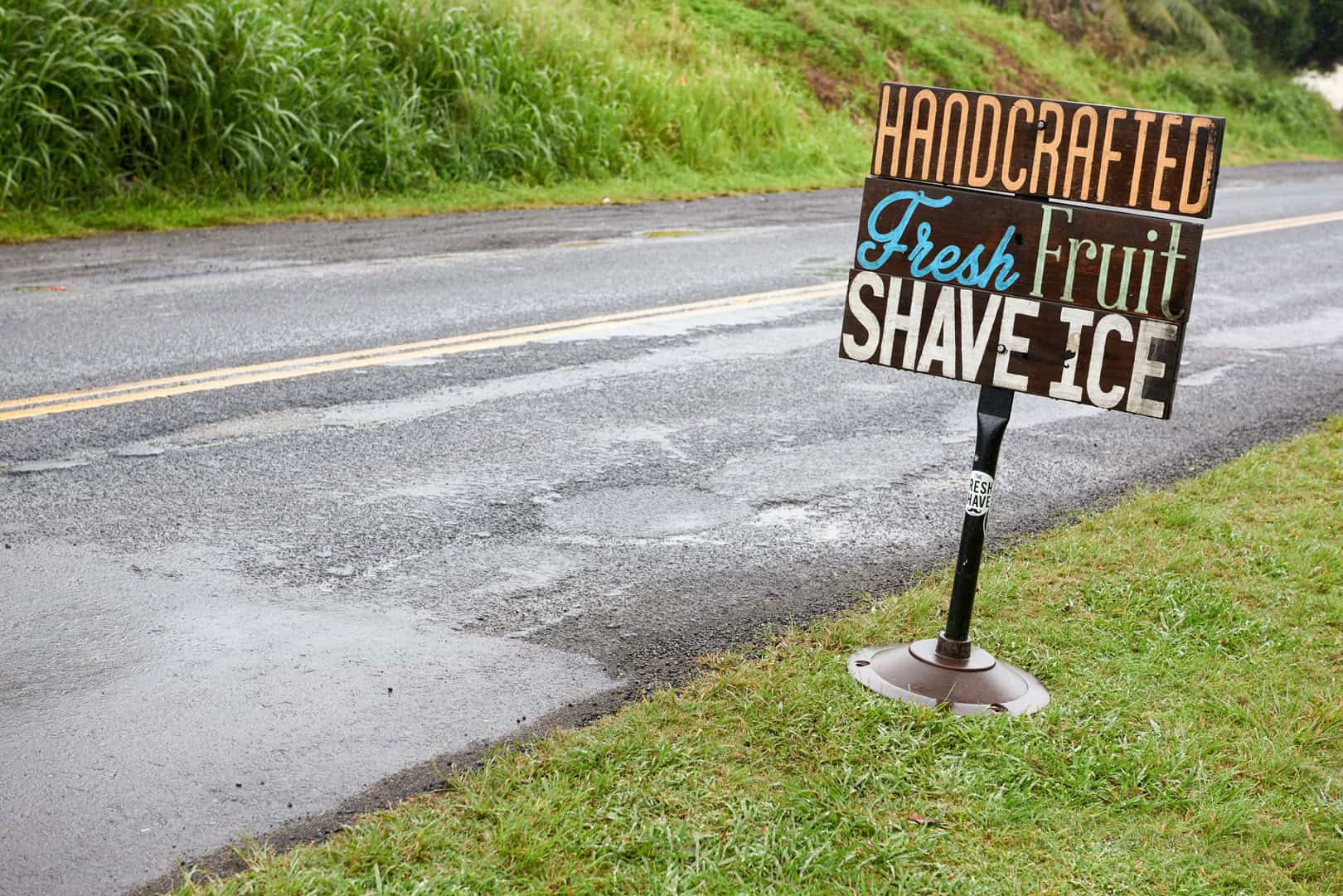 A sign on the side of the road in Kauai that says handcrafted fresh fruit shave ice