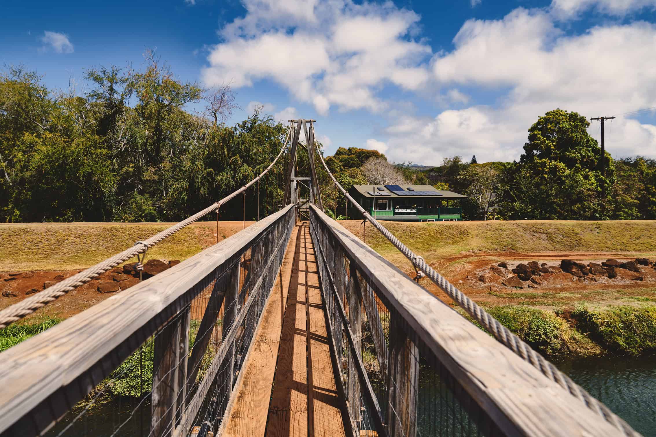 A wooden bridge with a house at the end of it