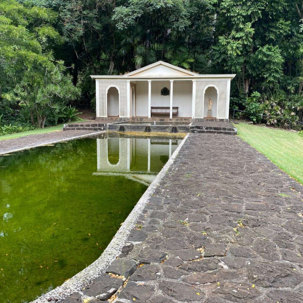 A small white house at the end of a long, narrow pool of water