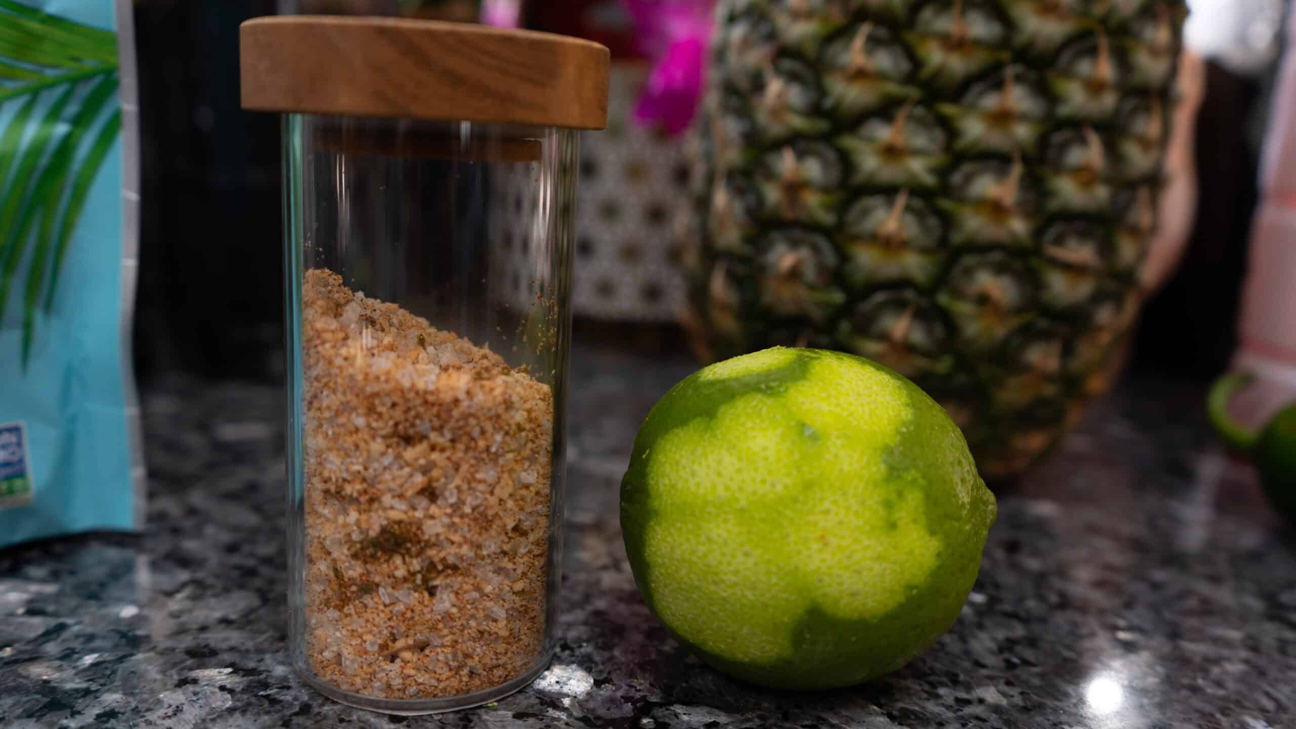 A jar of infused salt next to a lime