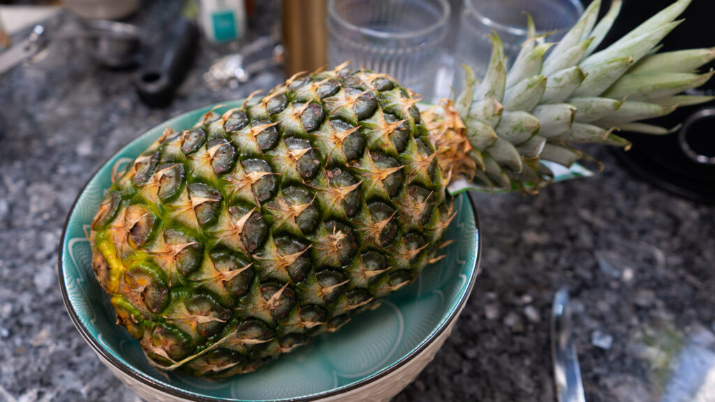 A large pineapple in a blue bowl