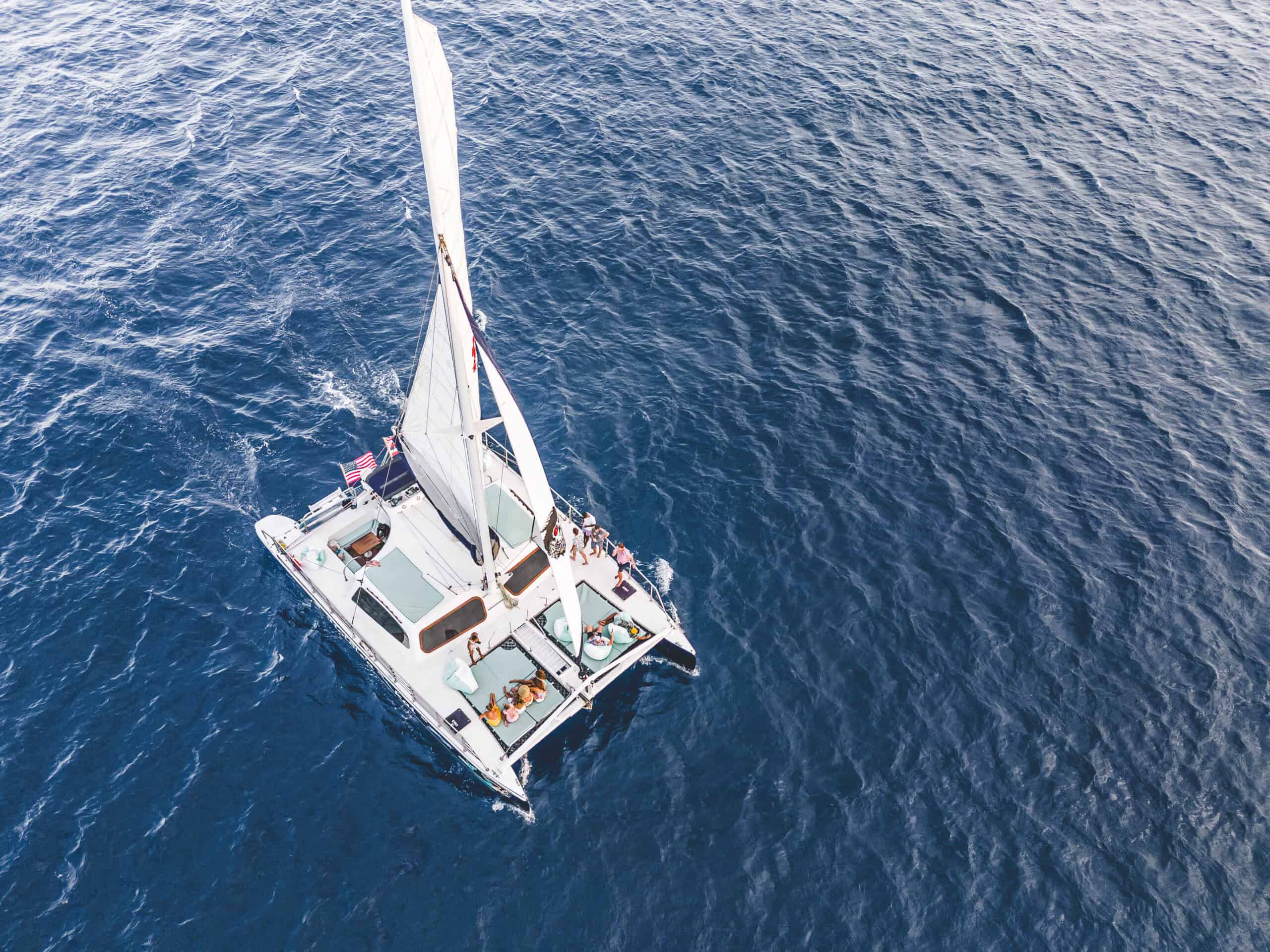 An aerial shot of a catamaran sail boat with turquoise mats to sit on.